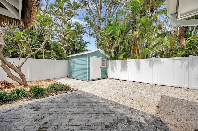 view of patio with a storage shed, a fenced backyard, and an outdoor structure