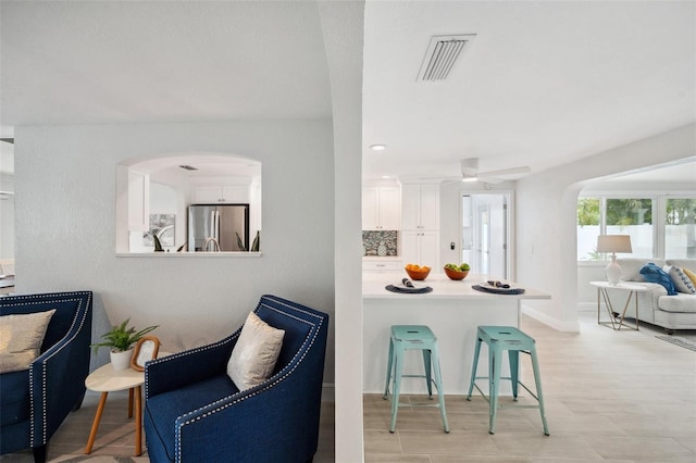 interior space featuring visible vents, baseboards, arched walkways, and ceiling fan