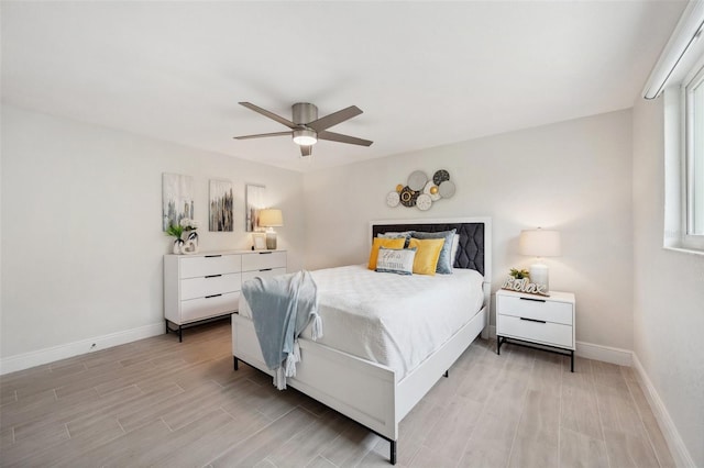 bedroom featuring baseboards, a ceiling fan, and wood tiled floor
