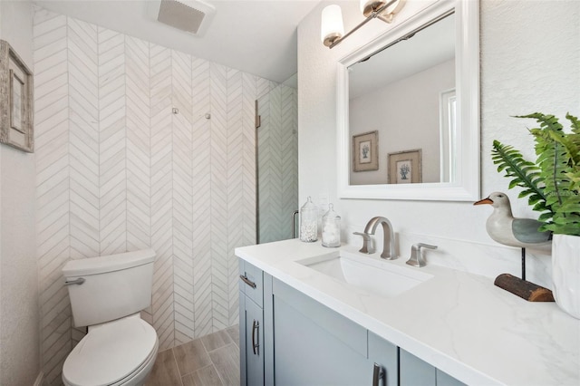 bathroom with vanity, tile walls, and toilet