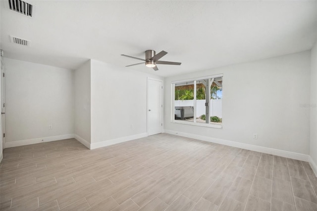 empty room with visible vents, ceiling fan, and baseboards