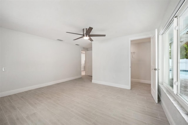 unfurnished room with light wood-style floors, visible vents, baseboards, and ceiling fan