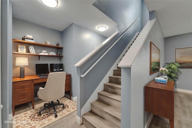 office area featuring baseboards, built in study area, and light wood-style floors