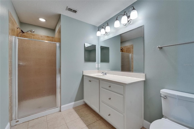 bathroom featuring visible vents, toilet, vanity, tile patterned flooring, and a stall shower