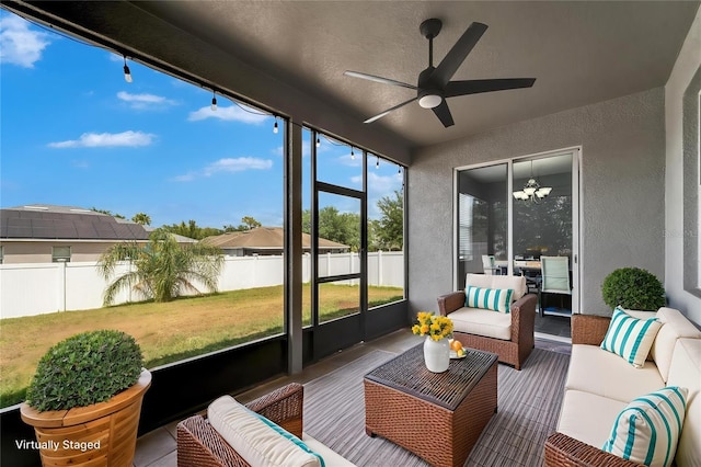 sunroom / solarium with ceiling fan and an outdoor living space