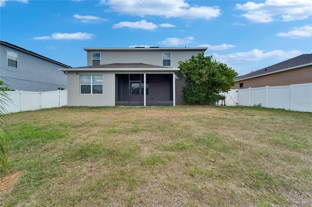 rear view of property featuring a sunroom, a yard, a fenced backyard, stucco siding, and roof with shingles