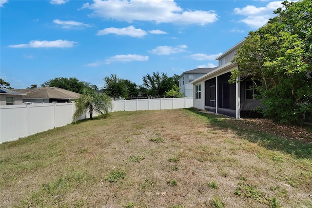 view of yard with a fenced backyard and a sunroom