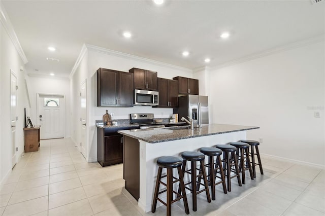 8953 Gallantree Pl, Land O Lakes, FL 34637 - kitchen with crown molding, a kitchen breakfast bar, light tile patterned flooring, a sink, and stainless steel appliances