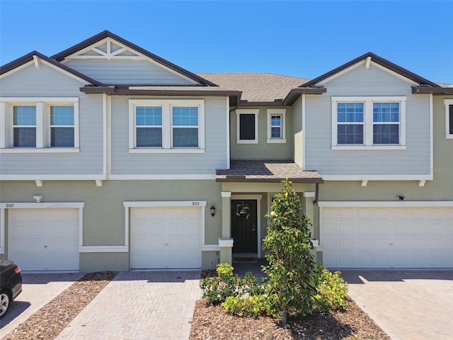 8953 Gallantree Pl, Land O Lakes, FL 34637 - townhome / multi-family property with a shingled roof, driveway, and an attached garage