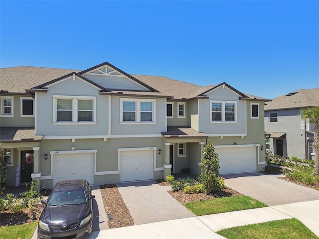 8953 Gallantree Pl, Land O Lakes, FL 34637 - view of property with driveway, a shingled roof, a garage, and stucco siding
