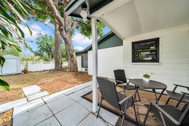 8115 N Ola Ave, Tampa, FL 33604 - view of patio featuring outdoor dining space, fence, an outbuilding, and a storage unit