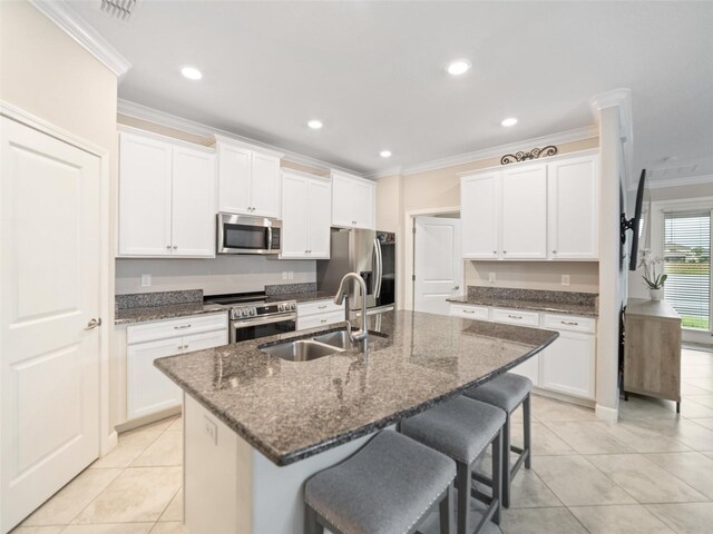 kitchen with a sink, a breakfast bar area, ornamental molding, and stainless steel appliances