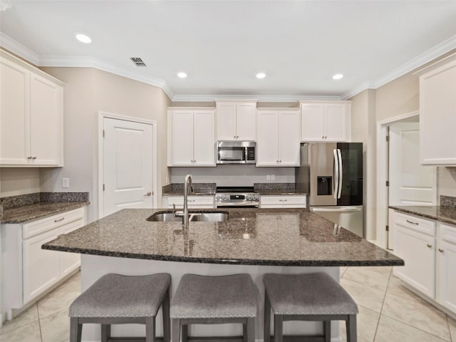 kitchen with a kitchen bar, visible vents, appliances with stainless steel finishes, a sink, and light tile patterned floors
