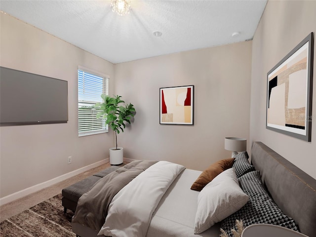 carpeted bedroom with baseboards and a textured ceiling