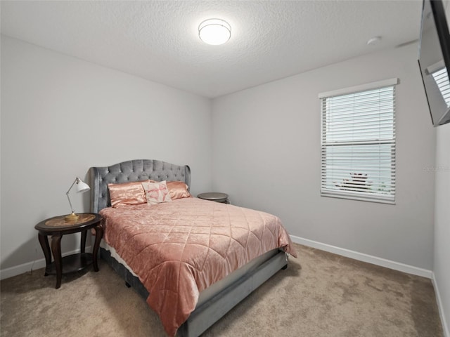 bedroom featuring carpet flooring, a textured ceiling, and baseboards