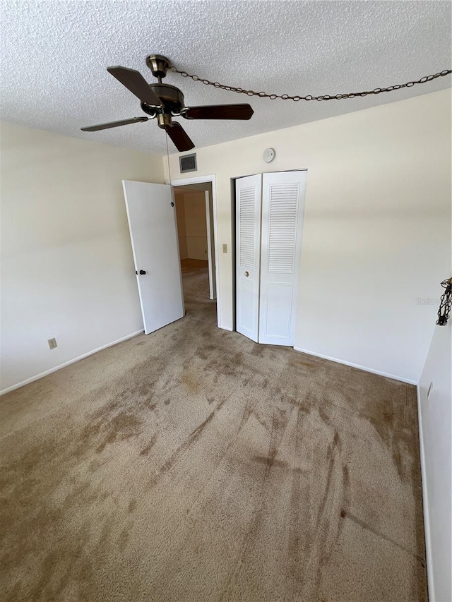 4715 Bay St NE Unit 235, Saint Petersburg, FL 33703 - unfurnished bedroom featuring a closet, a textured ceiling, a ceiling fan, carpet floors, and visible vents