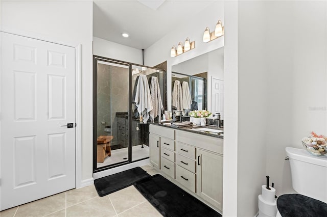 bathroom with tile patterned floors, toilet, a stall shower, and vanity