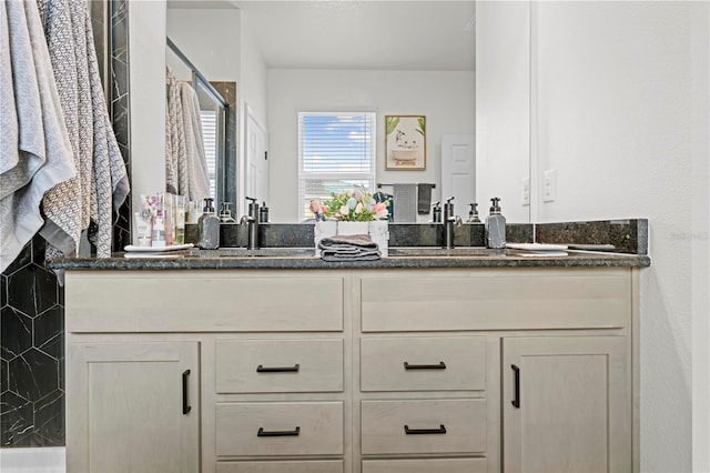 full bathroom featuring a shower stall, double vanity, and a sink
