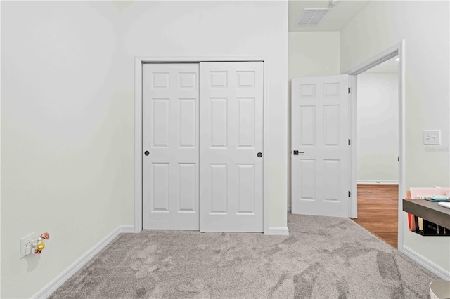 unfurnished bedroom with carpet, visible vents, a closet, and baseboards