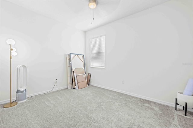 carpeted spare room featuring baseboards and ceiling fan