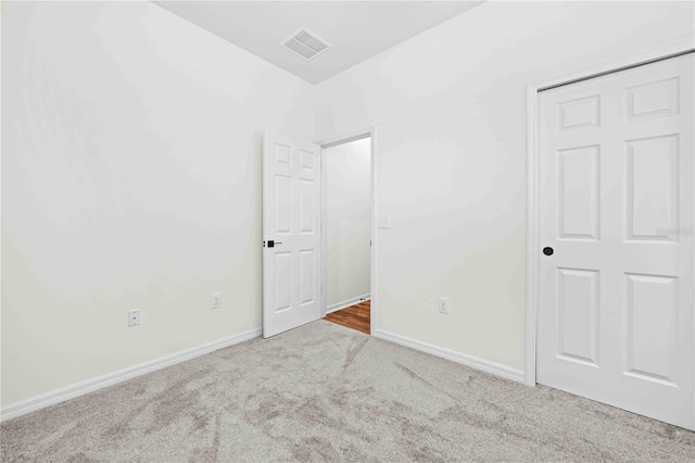 unfurnished bedroom with carpet, visible vents, and baseboards
