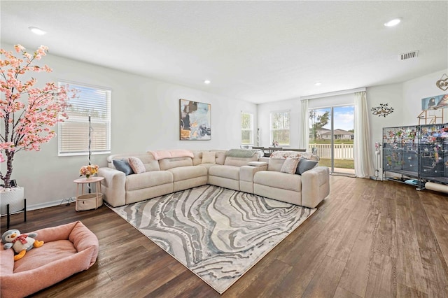 living area featuring a healthy amount of sunlight, recessed lighting, visible vents, and wood finished floors