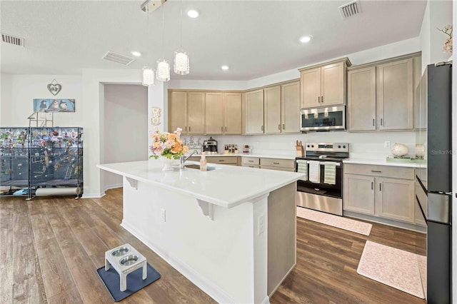 kitchen with stainless steel appliances, visible vents, light countertops, and dark wood-style floors