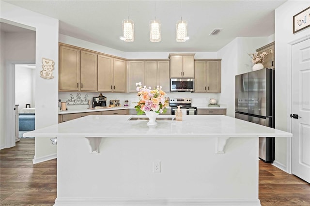 kitchen featuring a kitchen bar, visible vents, appliances with stainless steel finishes, dark wood-style flooring, and light countertops