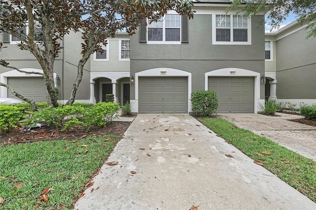 view of front of property featuring concrete driveway, stucco siding, and a garage