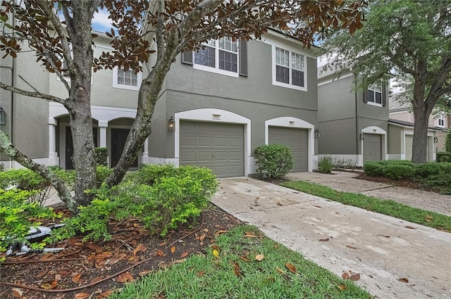 view of front facade featuring concrete driveway, stucco siding, and an attached garage