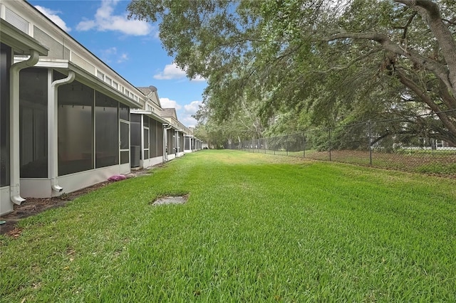 view of yard featuring a sunroom and a fenced backyard