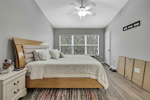 bedroom featuring baseboards, ceiling fan, wood finished floors, and lofted ceiling