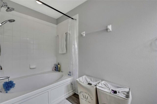 full bath featuring shower / tub combo and wood finished floors