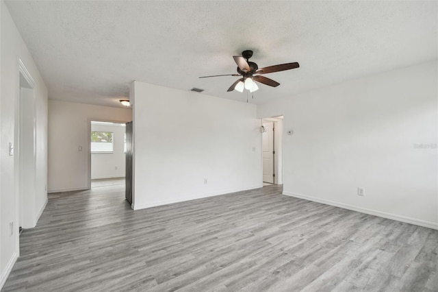 2401 Havana Dr, Clearwater, FL 33764 - unfurnished room with visible vents, baseboards, a ceiling fan, a textured ceiling, and wood finished floors