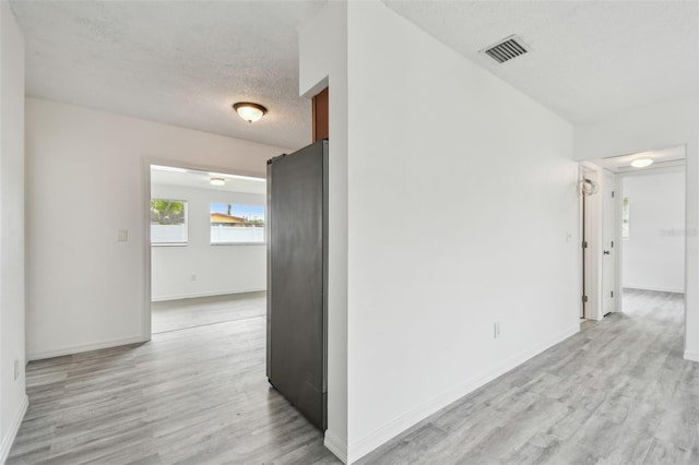 2401 Havana Dr, Clearwater, FL 33764 - corridor featuring light wood-style floors, baseboards, visible vents, and a textured ceiling