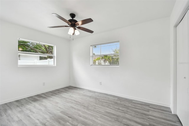 2401 Havana Dr, Clearwater, FL 33764 - unfurnished bedroom with a closet, multiple windows, baseboards, and wood finished floors
