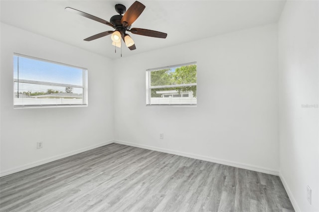 2401 Havana Dr, Clearwater, FL 33764 - spare room featuring baseboards, wood finished floors, and a healthy amount of sunlight
