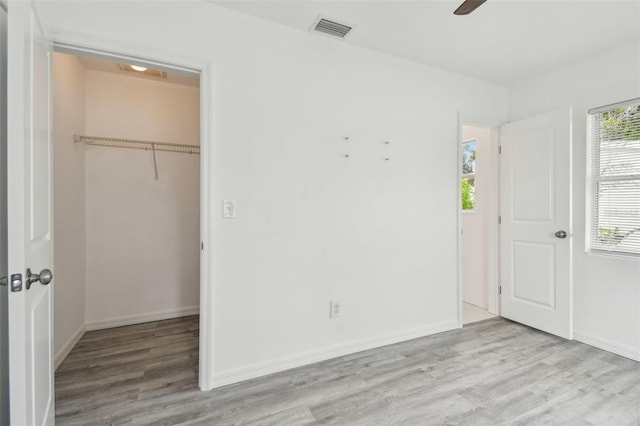 2401 Havana Dr, Clearwater, FL 33764 - unfurnished bedroom featuring a closet, visible vents, wood finished floors, a walk in closet, and baseboards