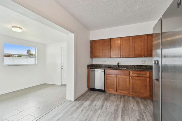 2401 Havana Dr, Clearwater, FL 33764 - kitchen featuring a sink, appliances with stainless steel finishes, dark stone counters, and light wood finished floors