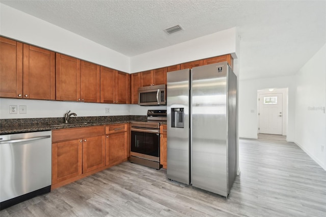 2401 Havana Dr, Clearwater, FL 33764 - kitchen with a textured ceiling, visible vents, appliances with stainless steel finishes, a sink, and light wood finished floors