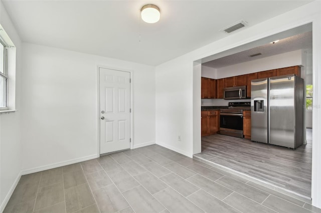 2401 Havana Dr, Clearwater, FL 33764 - kitchen featuring dark countertops, visible vents, baseboards, and appliances with stainless steel finishes