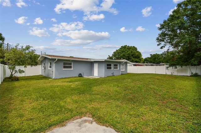 2401 Havana Dr, Clearwater, FL 33764 - back of property with a fenced backyard, stucco siding, and a lawn