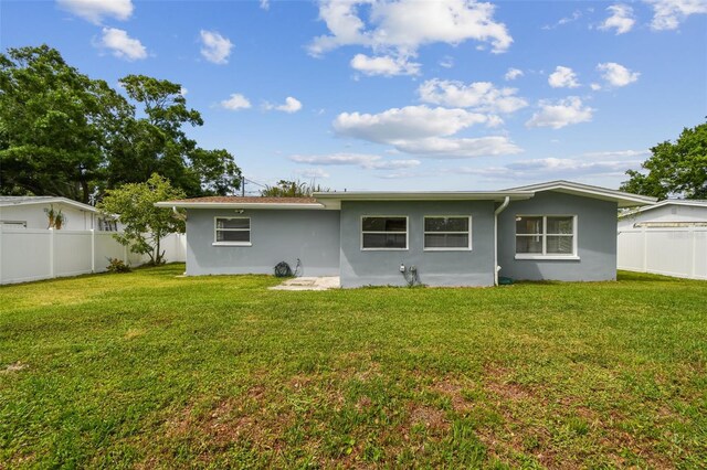2401 Havana Dr, Clearwater, FL 33764 - back of house with a fenced backyard, a lawn, and stucco siding