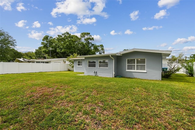 2401 Havana Dr, Clearwater, FL 33764 - rear view of house featuring fence, a lawn, and stucco siding