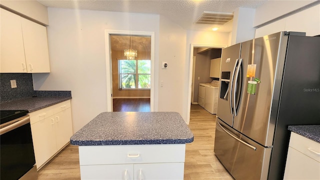 kitchen with light wood-type flooring, washing machine and clothes dryer, electric range oven, and stainless steel refrigerator with ice dispenser