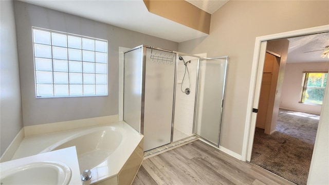 full bathroom featuring a sink, a shower stall, wood finished floors, and a garden tub