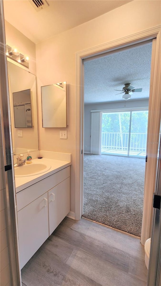 bathroom with vanity, a textured ceiling, a ceiling fan, and toilet