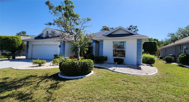 single story home with concrete driveway, a front yard, stucco siding, and a garage