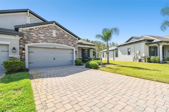 19325 Hawk Valley Dr, Tampa, FL 33647 - view of front of house featuring a front yard, a garage, stone siding, decorative driveway, and stucco siding
