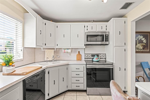 101 Dogwood Cir, Seminole, FL 33777 - kitchen featuring visible vents, light tile patterned floors, a sink, light countertops, and appliances with stainless steel finishes